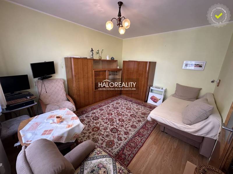 Wohnzimmer in einer 3-Zimmer-Wohnung mit Sesseln, Teppich und Schrank.