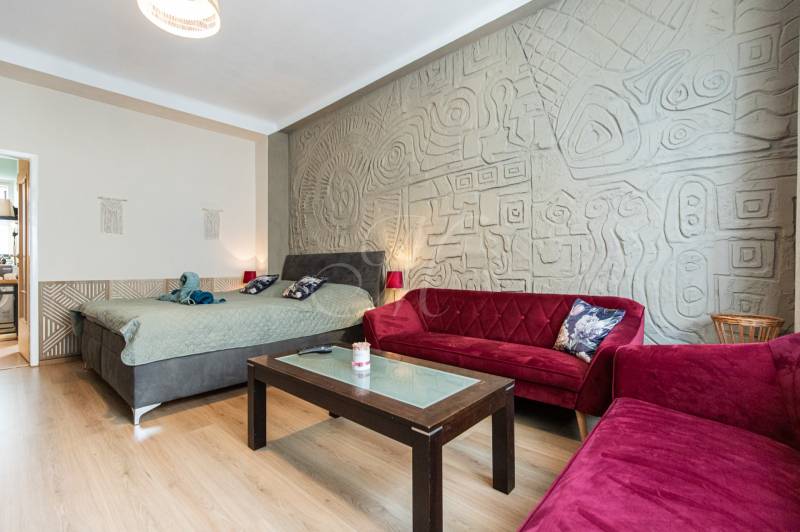Wohnzimmer in einer 2-Zimmer-Wohnung mit Sofas und dekorativer Wand.