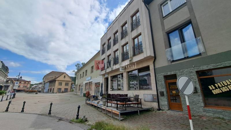 Das Gebäude in der Mostová-Straße in Ružomberok mit Terrasse und umliegenden historischen Bauwerken.