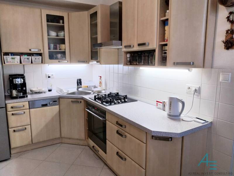 Küche in einer 4-Zimmer-Wohnung mit Holzschränken und modernen Geräten.