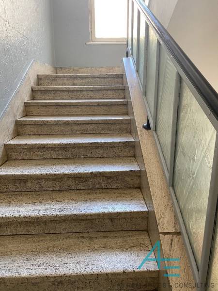 Eine Treppe mit Glasgeländer führt zu einem Fenster in einer 4-Zimmer-Wohnung.