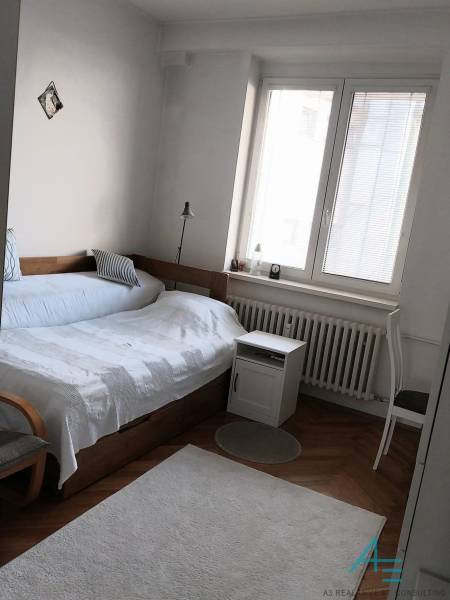 Schlafzimmer mit Bett, Lampe und Fenster in einer 4-Zimmer-Wohnung.