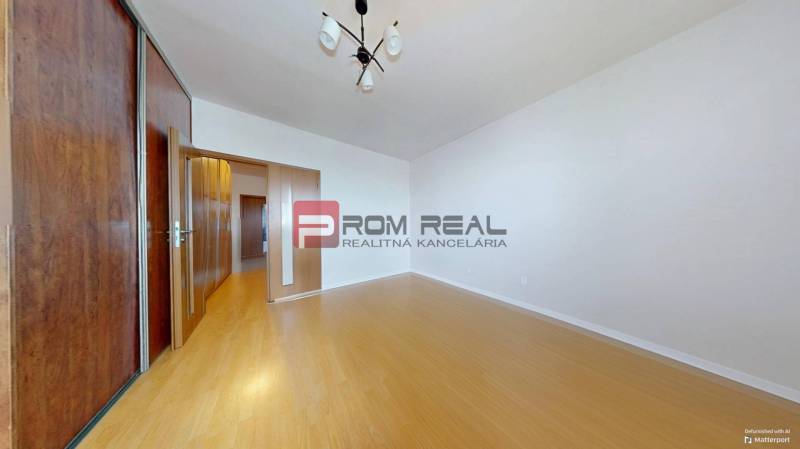 Ein Zimmer mit Holzboden, Einbauschrank und Beleuchtung in einer 3-Zimmer-Wohnung.