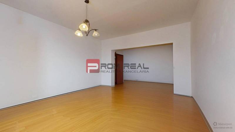 Geräumiges Wohnzimmer mit Holzboden und Kronleuchter in einer 3-Zimmer-Wohnung.