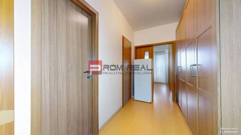 Der Flur in der 3-Zimmer-Wohnung mit Einbauschränken und heller Holzverkleidung.