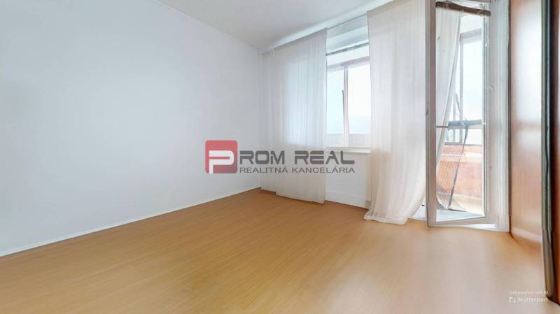 Ein leeres Zimmer in einer 3-Zimmer-Wohnung mit Laminatboden und Balkon.