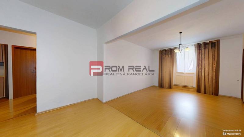 Innenraum einer 3-Zimmer-Wohnung mit Laminatboden und Vorhängen am Fenster.