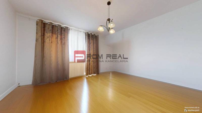 Ein leerer Raum mit Holzboden und Vorhängen, 3-Zimmer-Wohnung.