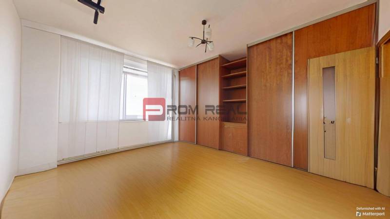 Zimmer in einer 3-Zimmer-Wohnung mit einem Holzschrank und einer Deckenleuchte.