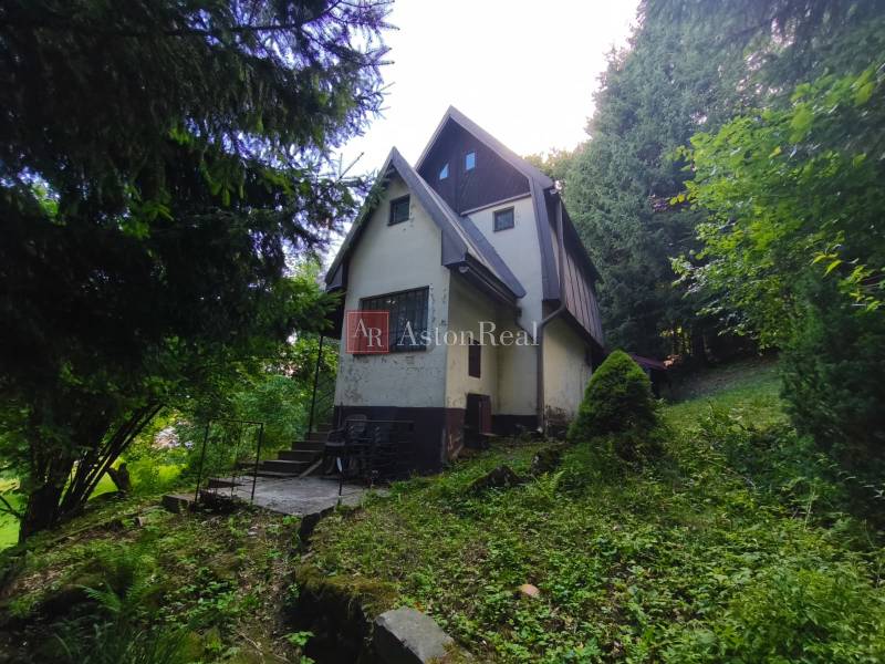 Hütte im Wald in Kordíky, Banská Bystrica, umgeben von Grün und Bäumen.