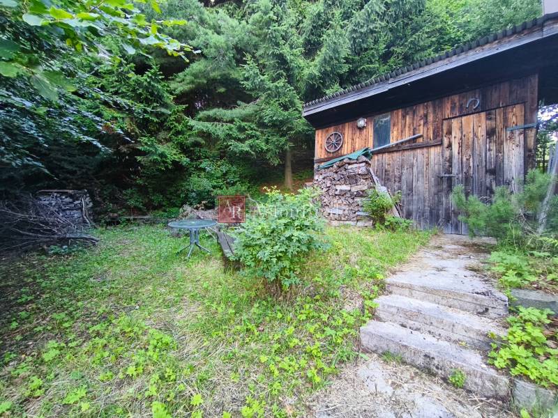 Eine Holzhütte umgeben von Grün in Kordíky in Banská Bystrica.