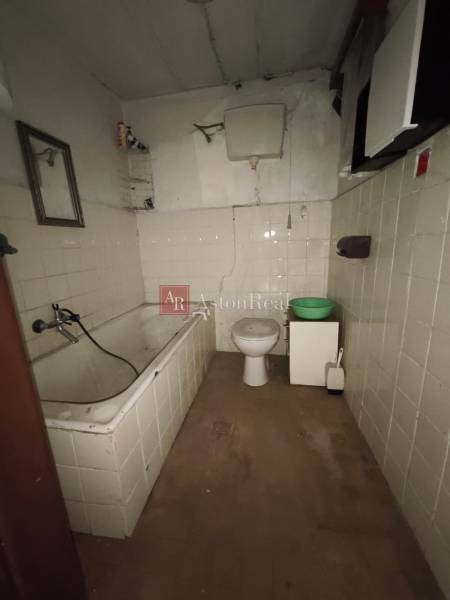 Badezimmer in einer Hütte mit Badewanne, Toilette und Boden mit Holzdekor.