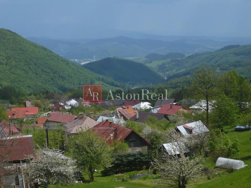 Ein Blick auf die Hütten in Kordíky bei Banská Bystrica mit malerischen Hügeln im Hintergrund.