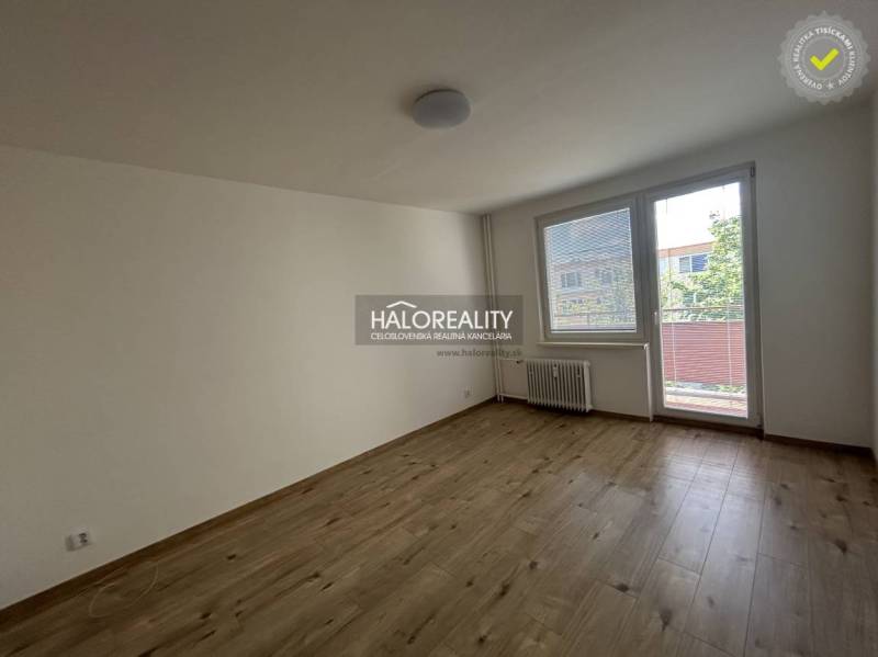 Ein geräumiges Zimmer mit einem großen Fenster und Balkontüren in einer 3-Zimmer-Wohnung.