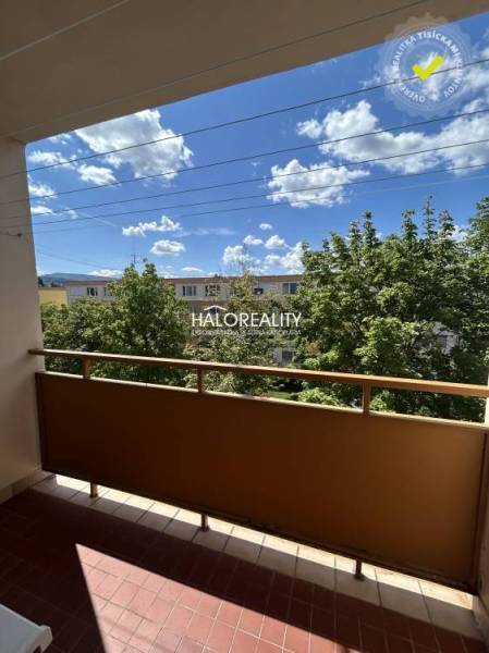 Der Balkon einer 3-Zimmer-Wohnung in Prievidza mit Blick auf Bäume und den Himmel.