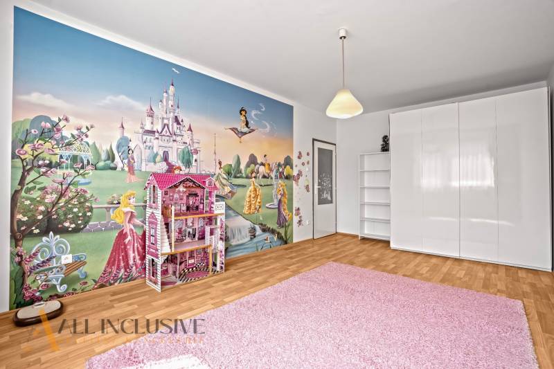 Kinderzimmer mit Märchentapete in einer 2-Zimmer-Wohnung, weiße Möbel und rosa Teppich.