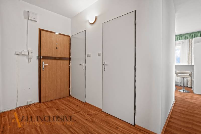 Eingangsflur in einer 2-Zimmer-Wohnung mit Holzboden und weißen Wänden.