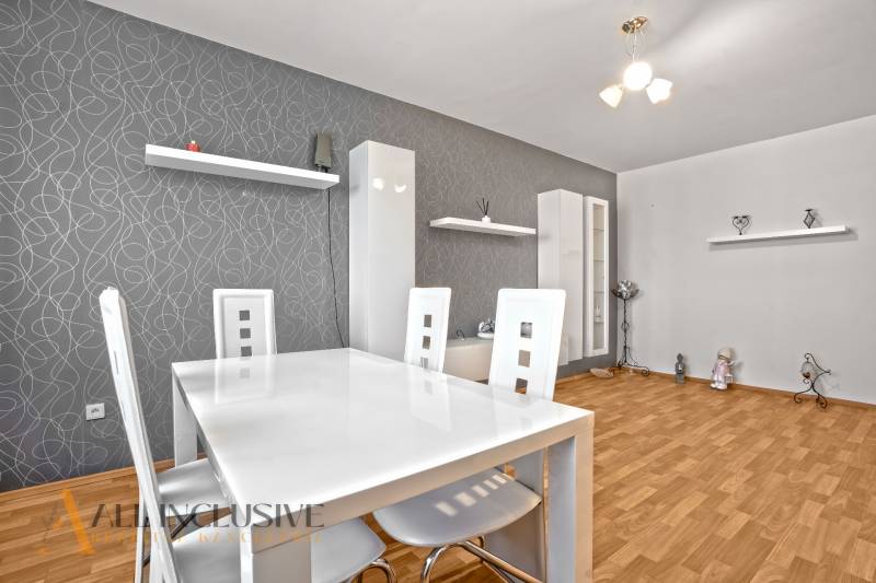 Esszimmer in einer 2-Zimmer-Wohnung mit Holzboden und weißen Möbeln.