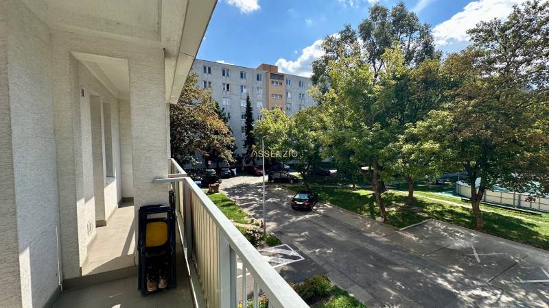 Ein Balkon mit Blick auf den Parkplatz und Grünflächen in einer 3-Zimmer-Wohnung in der Mesačná-Straße.
