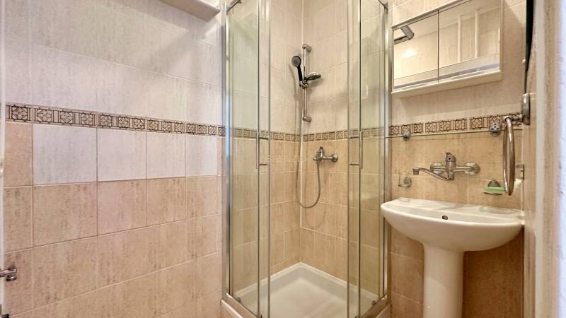 Duschkabine und Waschbecken mit Spiegelschrank im Badezimmer einer 3-Zimmer-Wohnung.