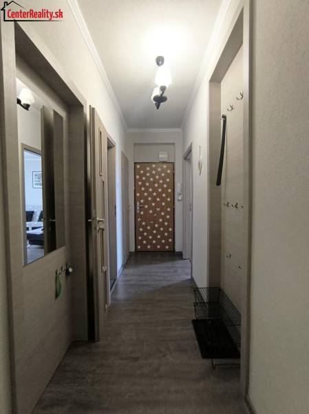 Der Flur in der 2-Zimmer-Wohnung mit Holztüren und dekorativen Sternen.