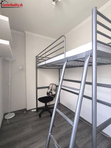 In der 2-Zimmer-Wohnung finden Sie ein Hochbett, einen Stuhl und eine Stehlampe.