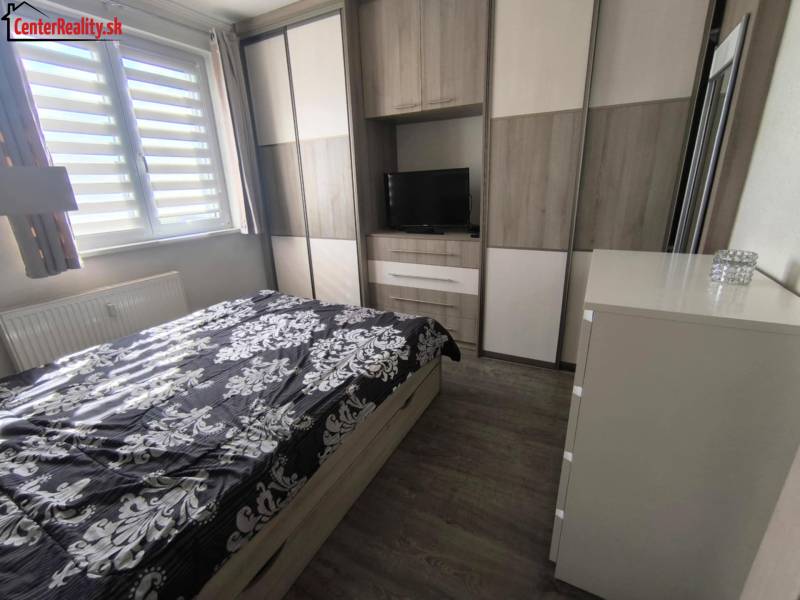 Schlafzimmer in einer 2-Zimmer-Wohnung mit Einbauschrank, Bett und Kommode.