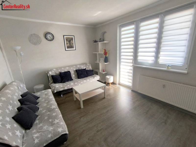 Wohnzimmer mit Sofa und dekorativen Elementen in einer Zweizimmerwohnung.