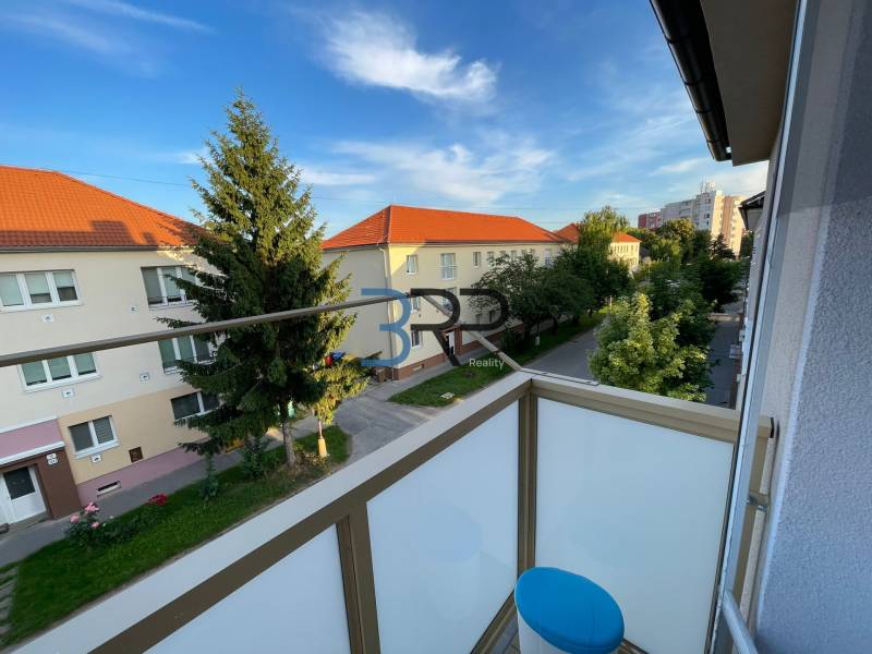 Der Balkon einer 2-Zimmer-Wohnung in der Hurbanova-Straße in Skalica mit Blick auf Bäume und Gebäude.