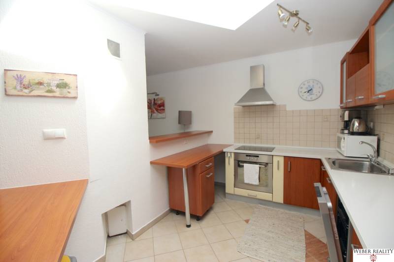 Eine Küche in einem Einfamilienhaus mit Geräten, einer Holzzeile und einer gefliesten Wand.