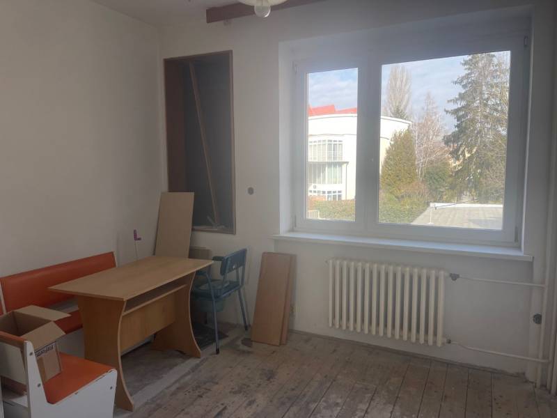 Innenraum eines Einfamilienhauses mit Fenster, Tisch und orangefarbener Bank.