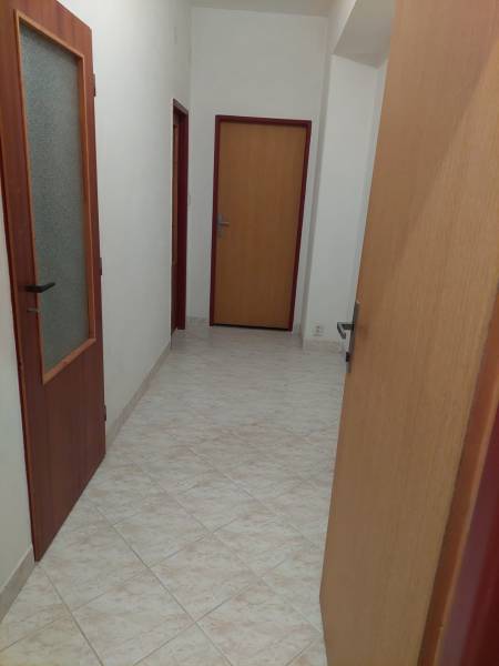 Flur in einem Einfamilienhaus mit Fliesen und Holztüren.