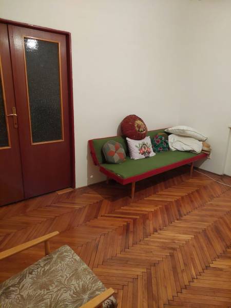 Innenraum eines Einfamilienhauses mit Holzboden, Sofa und Kissen in der Zimmerecke.