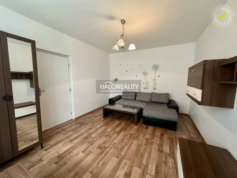 Wohnzimmer mit Sofa, Möbeln und dekorativen Aufklebern in einer Einzimmerwohnung.