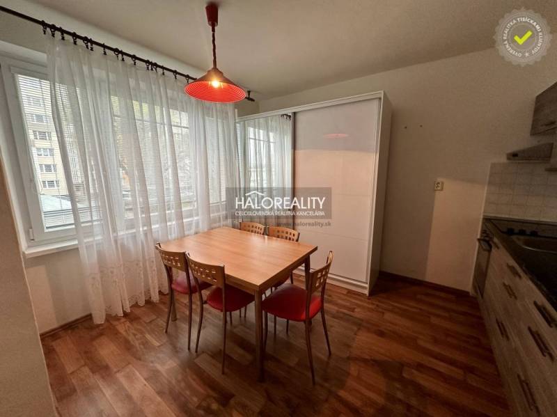 Essbereich in einer Einzimmerwohnung mit einem Holztisch und vier Stühlen.