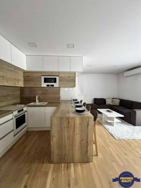 Wohnzimmer und Küche in einer 3-Zimmer-Wohnung mit Holzboden und Möbeln.
