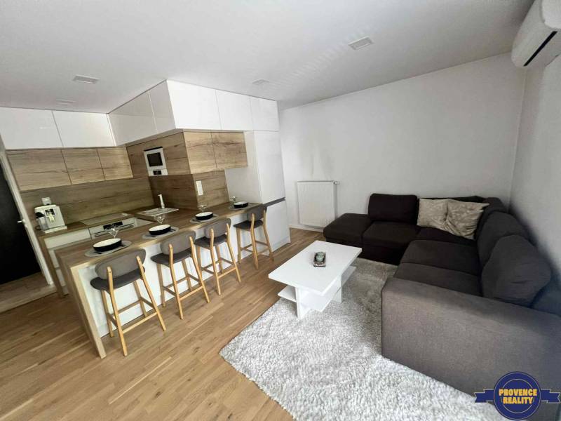 Wohnzimmer in einer 3-Zimmer-Wohnung mit Küche, Bartresen und Ecksofa.