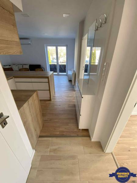 Helle Innenausstattung einer 3-Zimmer-Wohnung mit Holzboden und Zugang zur Terrasse.