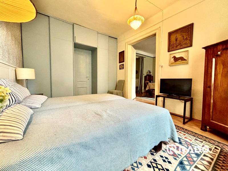 Schlafzimmer in einer 2-Zimmer-Wohnung mit Ehebett und antiken Möbeln.