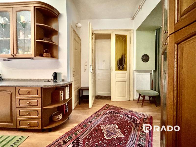 Küchenecke mit Holzmöbeln in einer 2-Zimmer-Wohnung, dekoriert mit einem orientalischen Teppich.