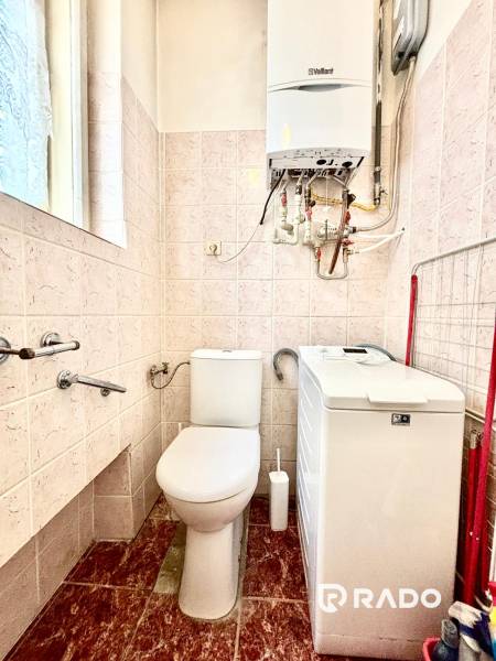 Badezimmer in einer 2-Zimmer-Wohnung mit WC, Waschmaschine und Gastherme an der Wand.