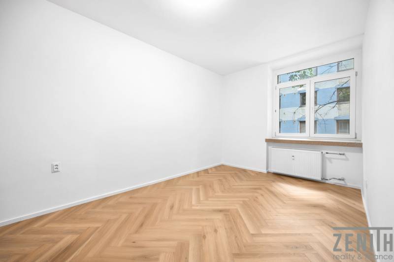 Ein Zimmer in einer 3-Zimmer-Wohnung mit Holzboden und einem großen Fenster.