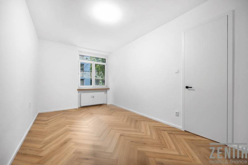 Ein Zimmer in einer 3-Zimmer-Wohnung mit Holzboden, weißen Wänden und einem Fenster.