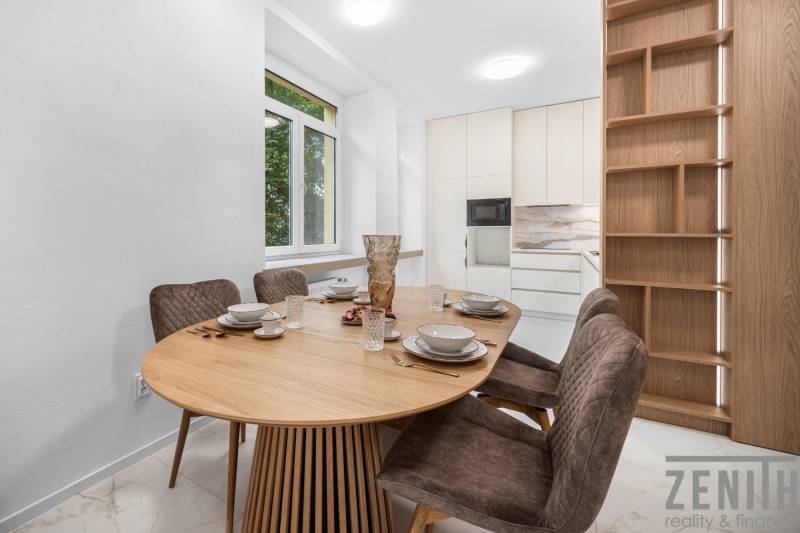 Helle Küche mit ovalem Tisch, vier Stühlen und großem Fenster in einer 3-Zimmer-Wohnung.