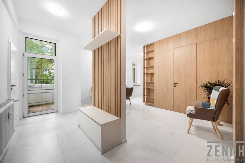 Helle Innenausstattung einer 3-Zimmer-Wohnung mit Holzelementen und einem Relaxsessel.