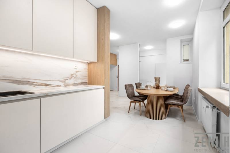 Küche mit Esstisch und vier Stühlen in einer 3-Zimmer-Wohnung.