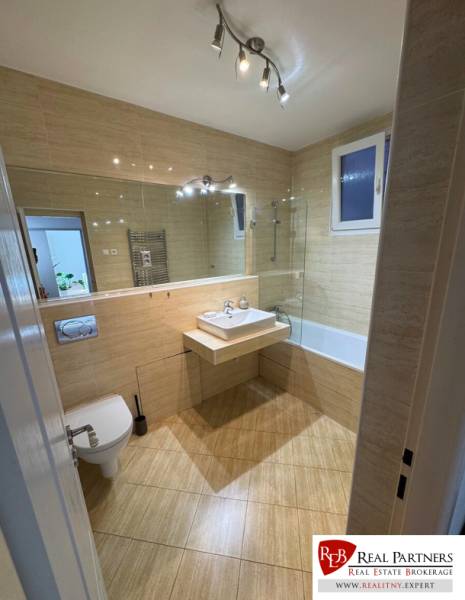 Badezimmer in einer 2-Zimmer-Wohnung mit Waschbecken, Badewanne und Toilette.