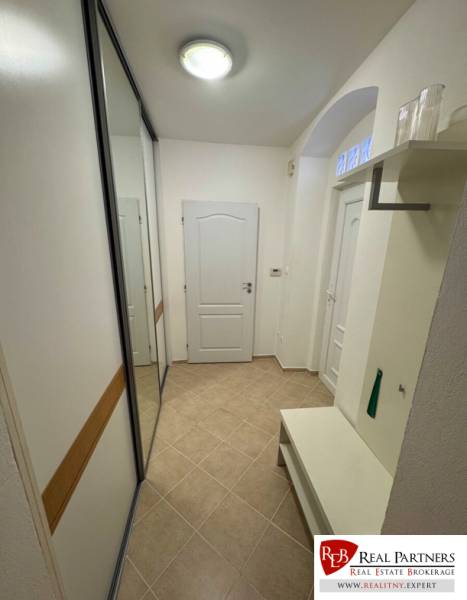 Flur in einer 2-Zimmer-Wohnung mit Einbauschrank und Bank, neutrales Design.