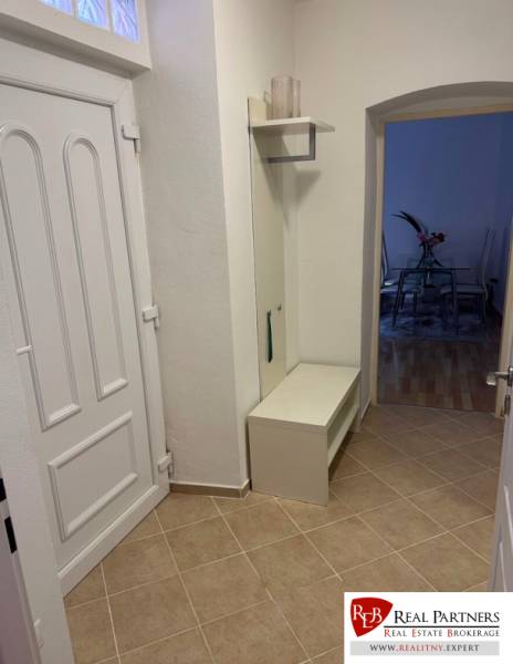 Eingangsflur einer 2-Zimmer-Wohnung mit weißen Möbeln und Fliesen.