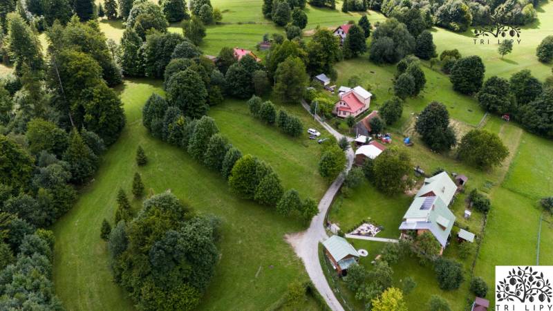 Luftaufnahme von Erholungsgrundstücken in Oščadnica, umgeben von dichtem Grün und Häusern.